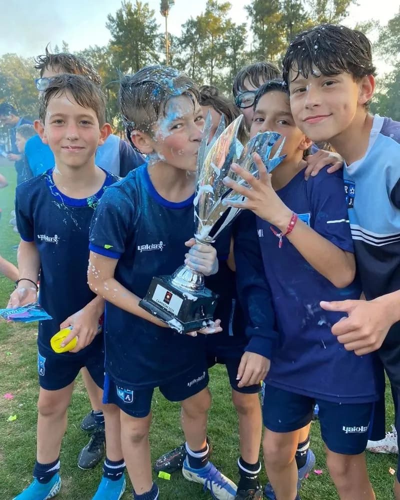 Chicos de Roma abrazados con una copa.